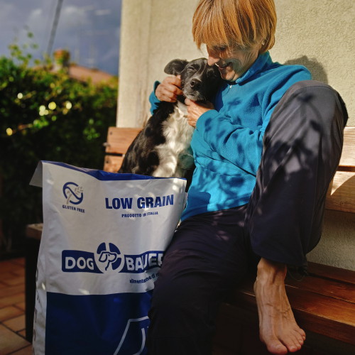 Signore tatuato con il suo Bulldog Inglese e il sacco delle sue crocchette Dermat Dogbauer