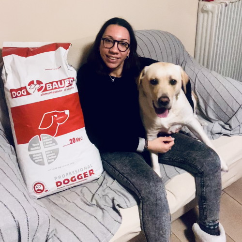 Ragazza inanellata con la sua Rottweiler e il sacco di crocchette Dogbauer