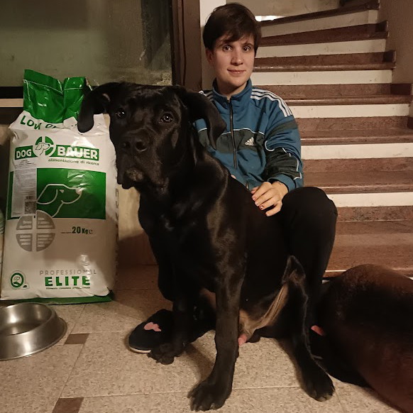 Ragazza inanellata con la sua Rottweiler e il sacco di crocchette Dogbauer