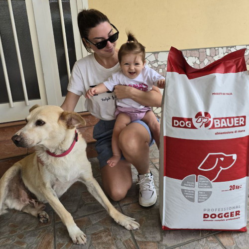 Ragazza inanellata con la sua Rottweiler e il sacco di crocchette Dogbauer