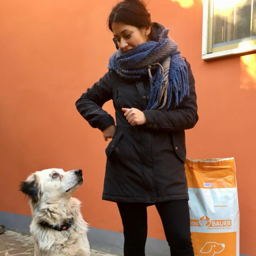 Ragazza con il proprio cane che si guardano simpaticamente e a lato il sacco di crocchette Dogbauer
