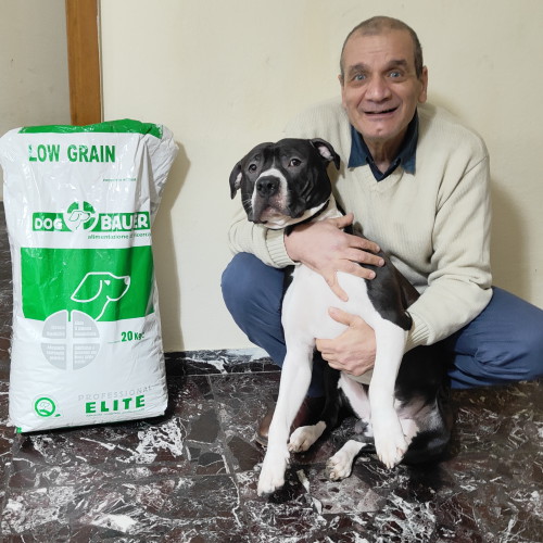 Uomofelice con il suo Amstaff in Braccio e il sacco delle crocchette Dogbauer